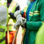 Close-up of construction workers wearing safety vests and gloves in Douala, Cameroon.