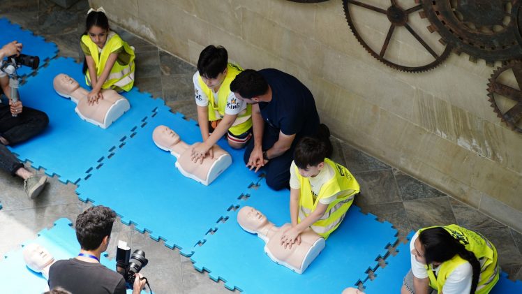A CPR workshop in Baku, Azerbaijan featuring participants practicing on mannequins with guidance from an instructor.