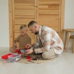 A father and son playing with toys indoors, enjoying quality bonding time.