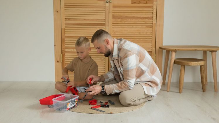 A father and son playing with toys indoors, enjoying quality bonding time.