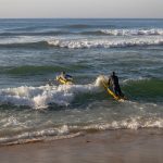 Lifeguards practicing surf maneuvers at Margate Beach, South Africa, promoting fitness.