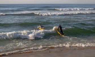 Lifeguards practicing surf maneuvers at Margate Beach, South Africa, promoting fitness.