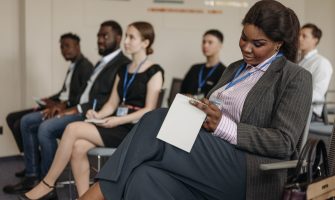 Business professionals engaged in a seminar, taking notes and listening attentively.