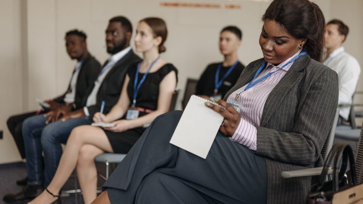Business professionals engaged in a seminar, taking notes and listening attentively.