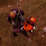Rope access professionals engaging in technical rescue training during a daring outdoor adventure.