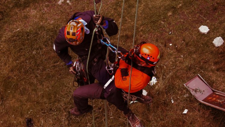 Rope access professionals engaging in technical rescue training during a daring outdoor adventure.