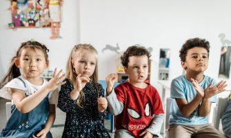 A group of diverse children engaged in a fun activity in a preschool classroom setting.