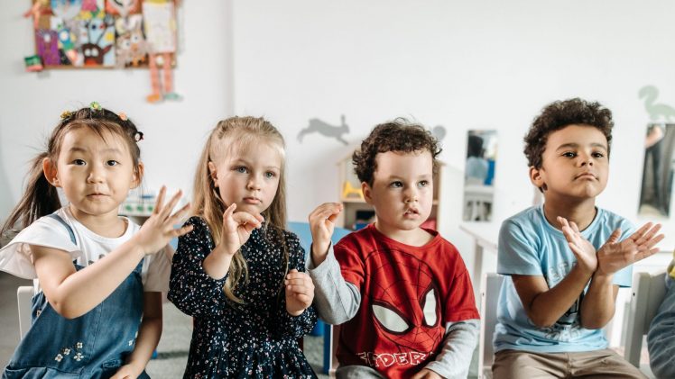 A group of diverse children engaged in a fun activity in a preschool classroom setting.