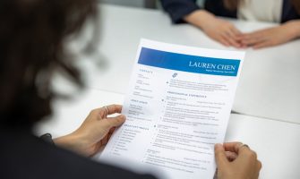 Uma Mulher Esta Lendo Um Curriculo Em Uma Mesa 9si2noVCVH8