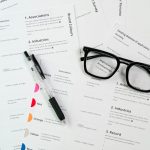 Um Par De Oculos Sentados Em Cima De Uma Pilha De Papel RqZaKEjRrdQ