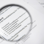 Close-up of a business document text under a magnifying glass.