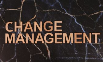 Wooden letters spelling 'Change Management' on a dark marble surface, emphasizing business change.