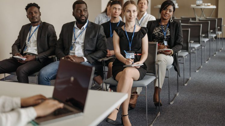 Diverse group of business professionals attentively attending a conference session.
