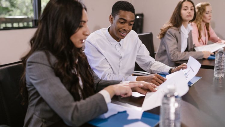 Diverse colleagues engaged in a business discussion at a conference table.