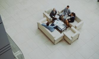 Aerial view of a group business meeting in a modern office setting.