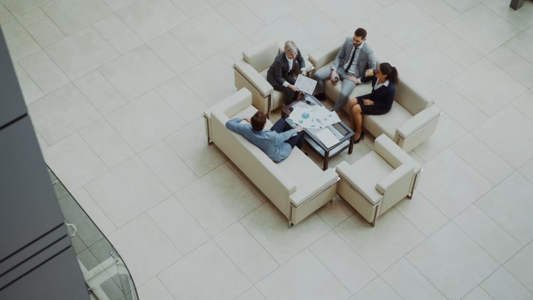 Aerial view of a group business meeting in a modern office setting.