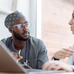 Two healthcare workers in conversation, focusing on collaboration and patient care.