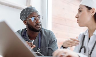 Two healthcare workers in conversation, focusing on collaboration and patient care.