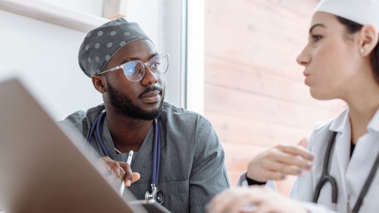Two healthcare workers in conversation, focusing on collaboration and patient care.