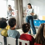 Children in a kindergarten classroom engaging with letters during a learning session.