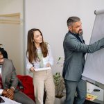 Diverse group of business professionals engaging in an office presentation, fostering teamwork and collaboration.