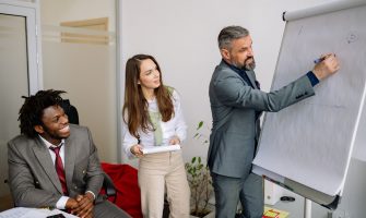 Diverse group of business professionals engaging in an office presentation, fostering teamwork and collaboration.
