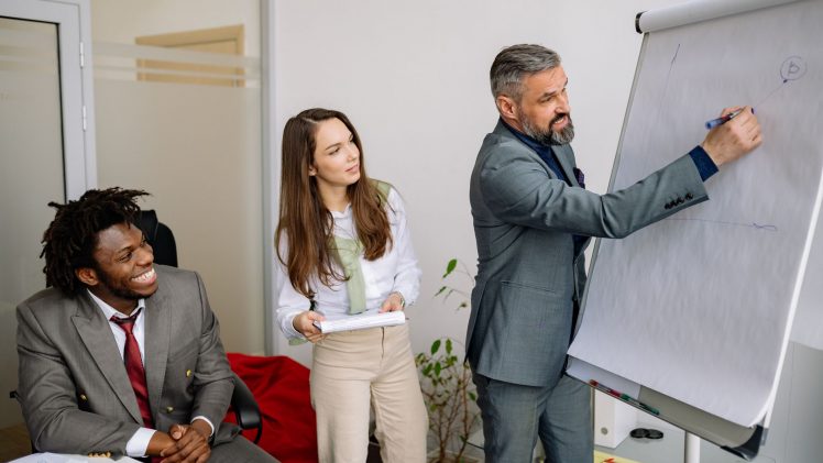 Diverse group of business professionals engaging in an office presentation, fostering teamwork and collaboration.