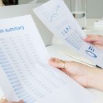 Two business professionals analyzing reports in a modern office setting.