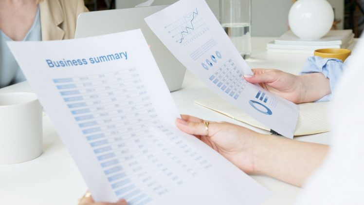 Two business professionals analyzing reports in a modern office setting.