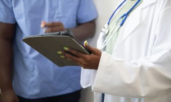 a doctor showing a patient something on the tablet
