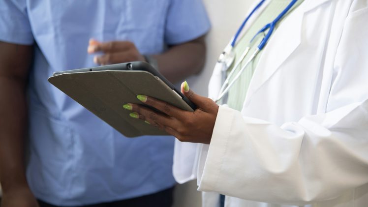 a doctor showing a patient something on the tablet