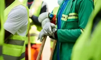 Close-up of construction workers wearing safety vests and gloves in Douala, Cameroon.