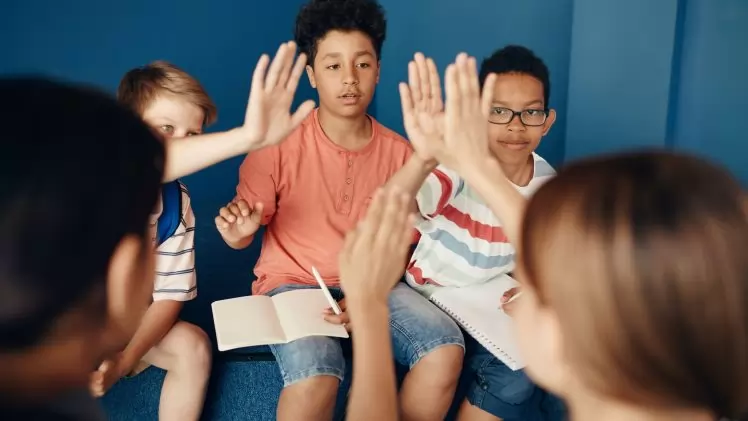 Group of diverse kids collaborating and learning together in a classroom setting.