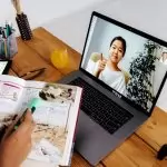 Online teaching session with digital tools, featuring a woman on a laptop screen and educational materials.