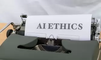 Close-up of vintage typewriter with 'AI ETHICS' typed on paper, emphasizing technology and responsibility.