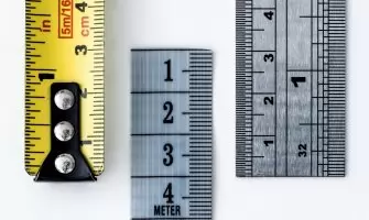 High-resolution image of a tape measure and rulers, showing precise millimeter, centimeter, and inch markings.