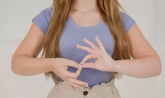 Close-up of a woman communicating through sign language indoors, isolated on a white background.