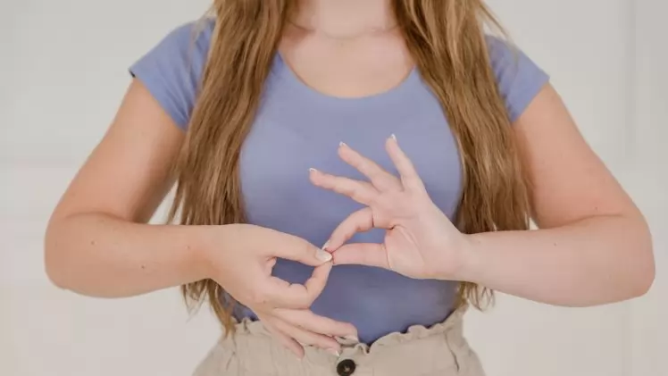 Close-up of a woman communicating through sign language indoors, isolated on a white background.