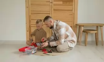 A father and son playing with toys indoors, enjoying quality bonding time.