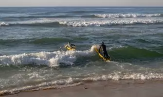 Lifeguards practicing surf maneuvers at Margate Beach, South Africa, promoting fitness.