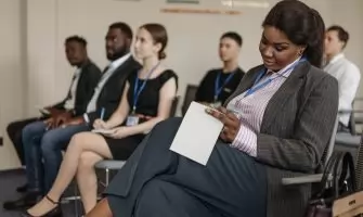 Business professionals engaged in a seminar, taking notes and listening attentively.