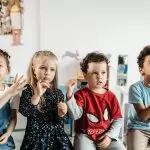 A group of diverse children engaged in a fun activity in a preschool classroom setting.