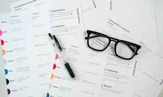 Um Par De Oculos Sentados Em Cima De Uma Pilha De Papel RqZaKEjRrdQ