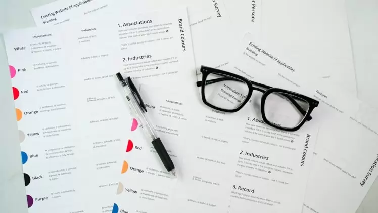 Um Par De Oculos Sentados Em Cima De Uma Pilha De Papel RqZaKEjRrdQ