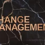 Wooden letters spelling 'Change Management' on a dark marble surface, emphasizing business change.
