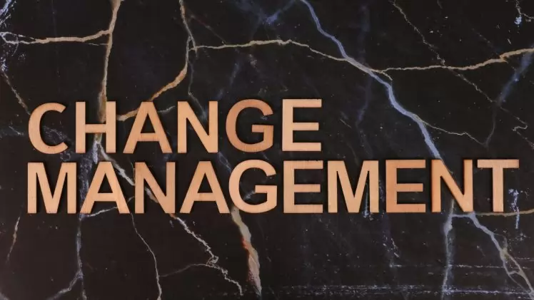 Wooden letters spelling 'Change Management' on a dark marble surface, emphasizing business change.