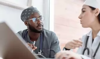 Two healthcare workers in conversation, focusing on collaboration and patient care.
