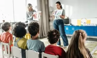 Children in a kindergarten classroom engaging with letters during a learning session.